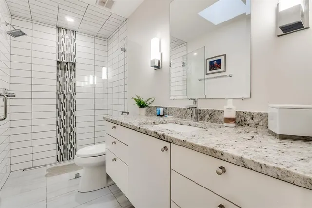 a bathroom with a granite countertop sink toilet and shower