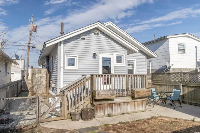 a view of a house with wooden deck and furniture