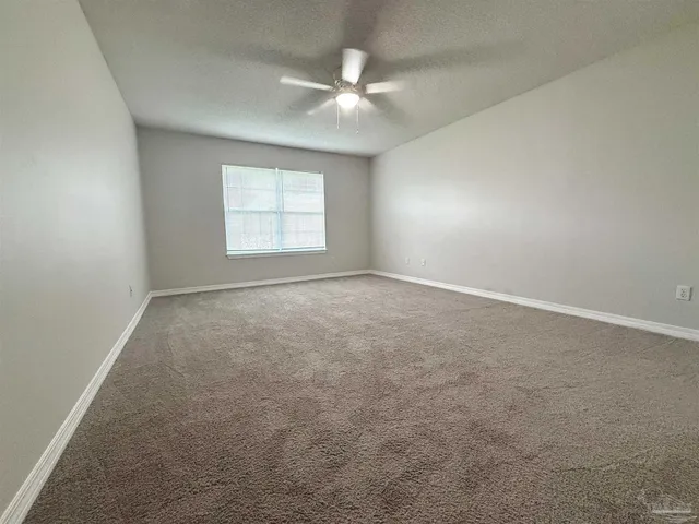 an empty room with a window and a ceiling fan