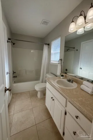 a bathroom with a granite countertop sink a toilet and a mirror