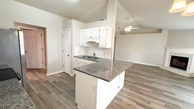 a kitchen with granite countertop a sink and a stove top oven