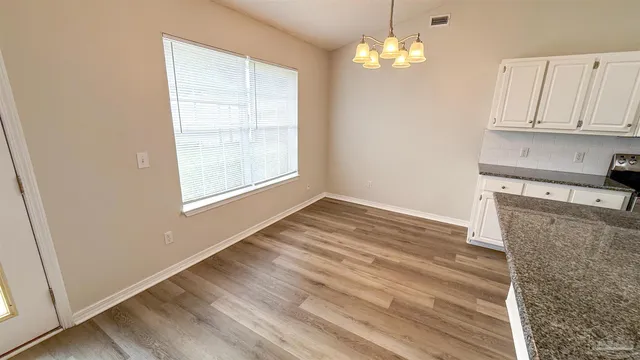 a view of a kitchen with wooden floor and a window