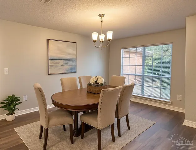 a view of a dining room with furniture a chandelier and wooden floor