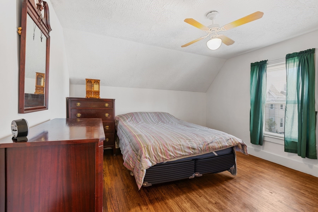 20 Trinity Avenue Lynn, MA 01902 - Photo 16 of 29 a bedroom with a bed and dresser with mirror