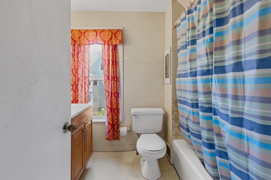 20 Trinity Avenue Lynn, MA 01902 - Photo 23 of 29 a white toilet sitting next to a shower curtain