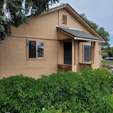 a view of a white house next to a yard