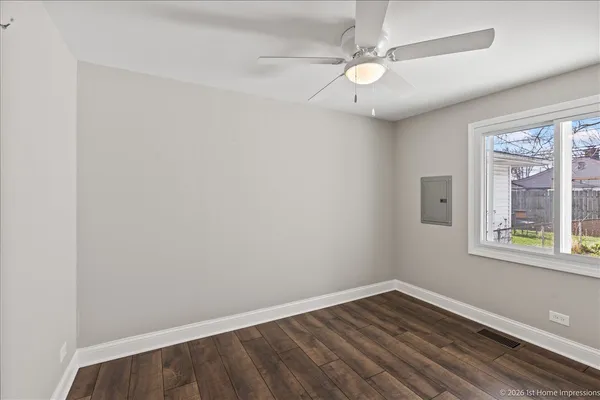 an empty room with a window and wooden floor