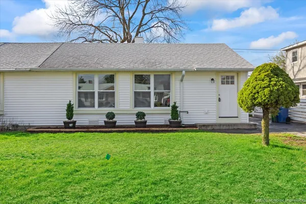 a front view of a house with a garden and plants