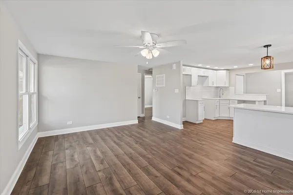 wooden floor in an empty room with a kitchen