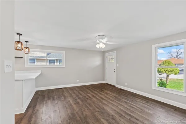 a view of empty room with wooden floor and window