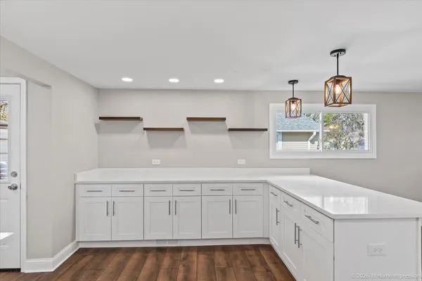 a kitchen with white cabinets and sink