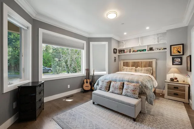 a view of a patio with table and chairs under an umbrella with large trees