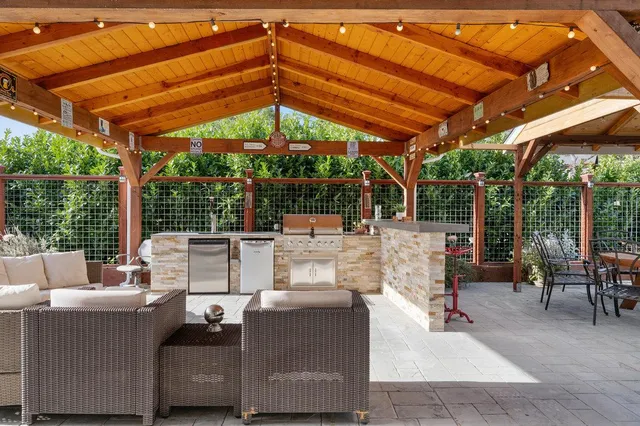 a view of a patio with table and chairs potted plants and a palm tree