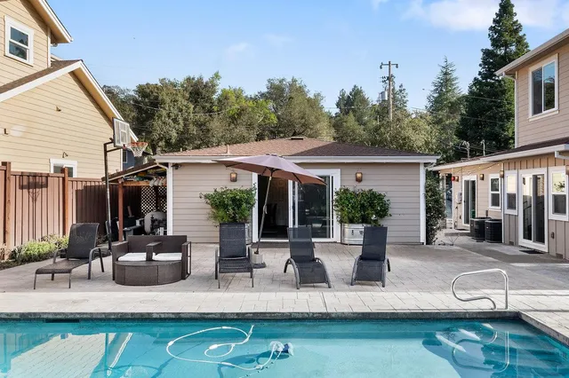 a backyard of a house with a swing table and chairs