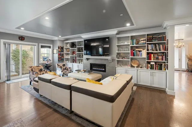 a living room with furniture a flat screen tv and a fireplace