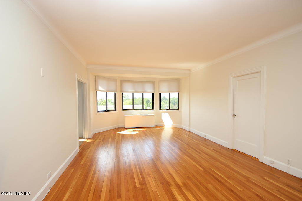 47 Lafayette Place, Unit 5D Greenwich, CT 06830 - Photo 3 of 8 a view of an empty room with wooden floor and a window
