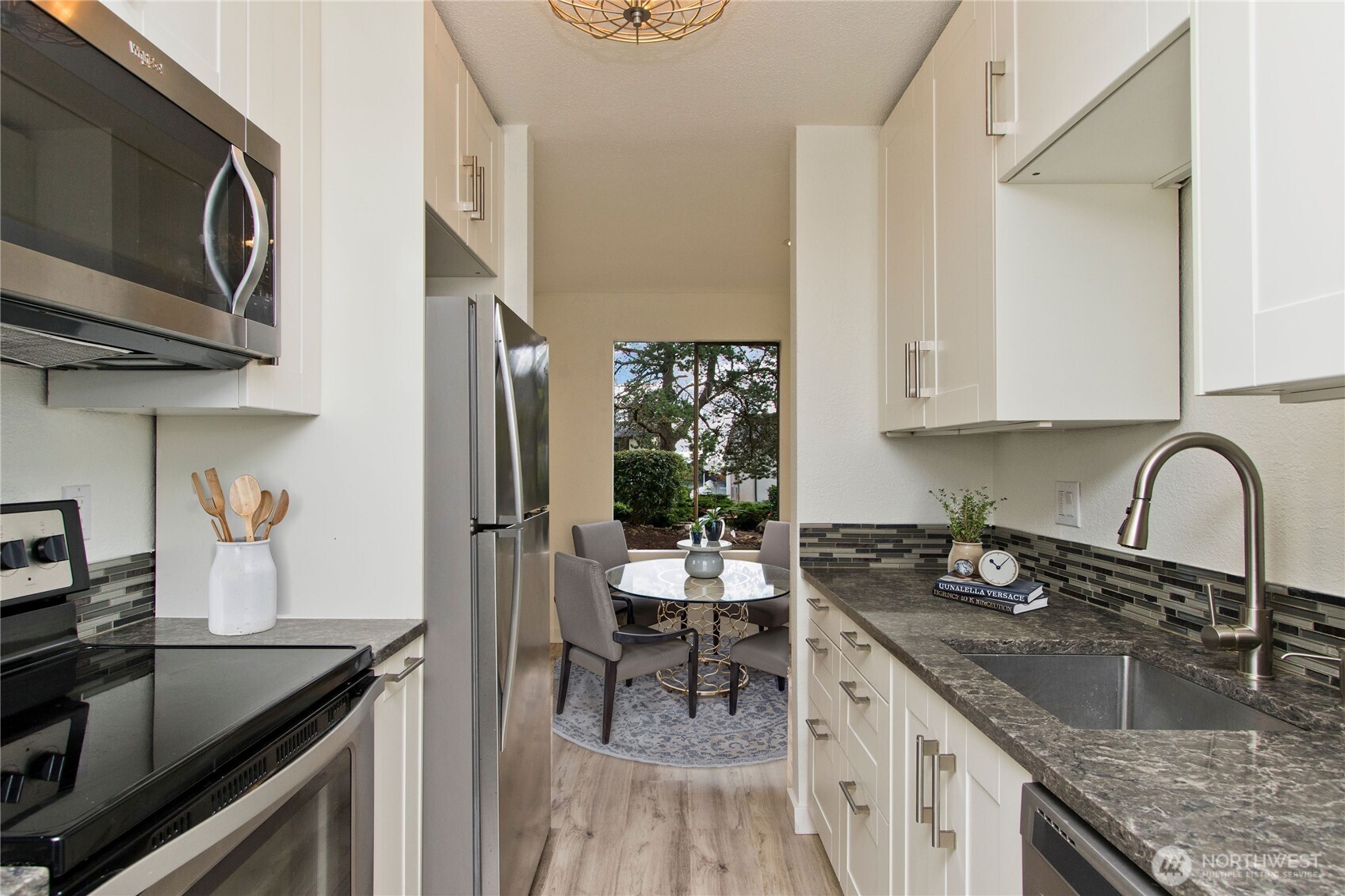 12515 Northeast 145th Place, Unit D127 Kirkland, WA 98034 - Photo 11 of 21 a kitchen with granite countertop a sink stainless steel appliances and cabinets