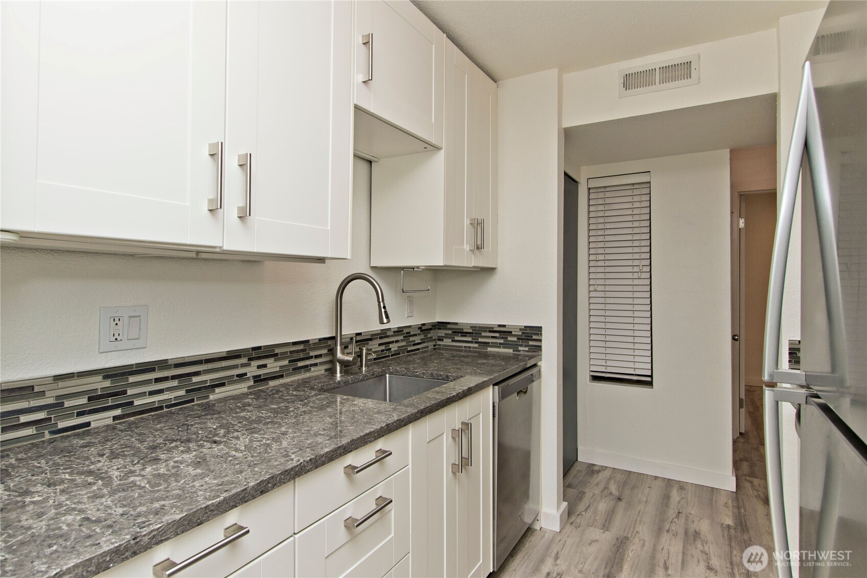 12515 Northeast 145th Place, Unit D127 Kirkland, WA 98034 - Photo 13 of 21 a kitchen with granite countertop a sink a stove and cabinets