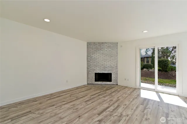 a view of empty room with wooden floor and fireplace