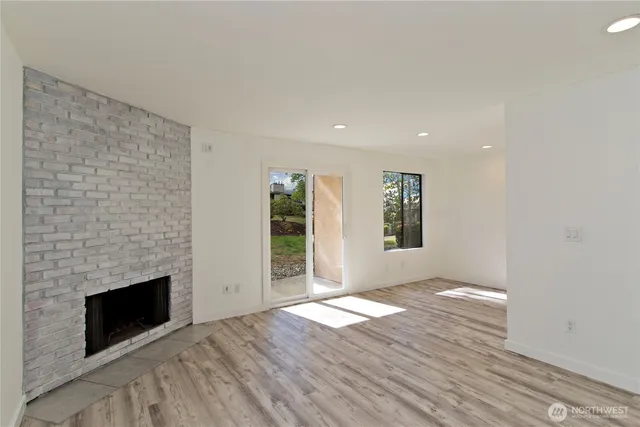 a view of empty room with wooden floor and fireplace
