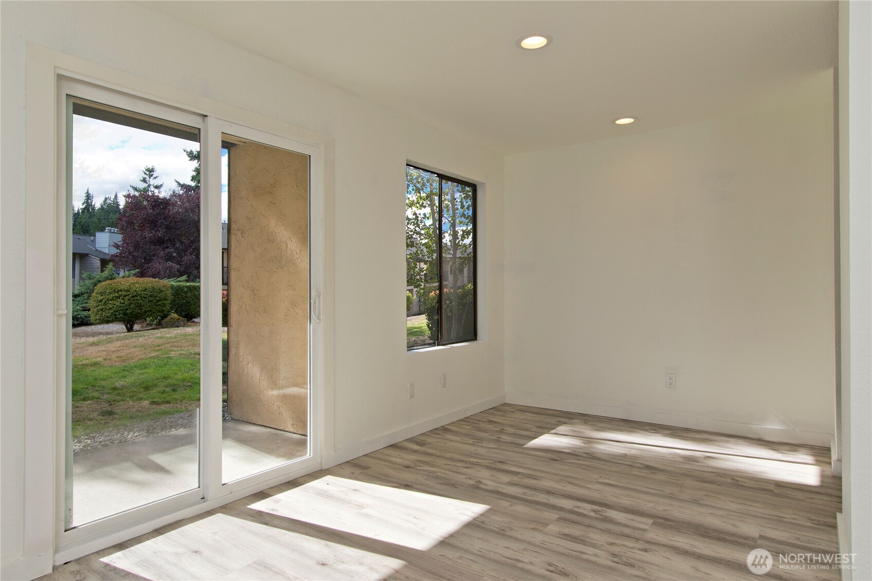 12515 Northeast 145th Place, Unit D127 Kirkland, WA 98034 - Photo 8 of 21 a view of an empty room with wooden floor and a window