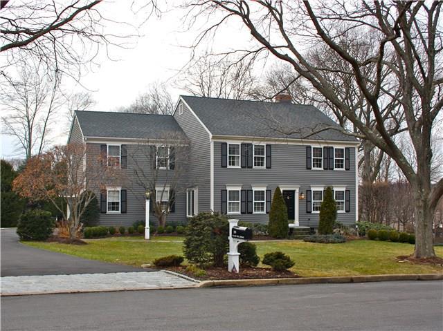 a front view of a house with a garden and trees