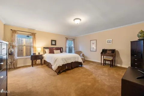 a spacious bedroom with a bed and a flat screen tv