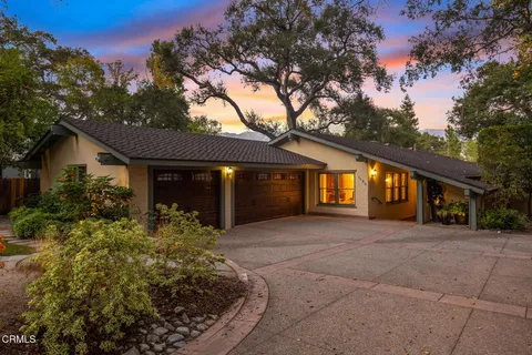 a front view of a house with a garden and outdoor seating