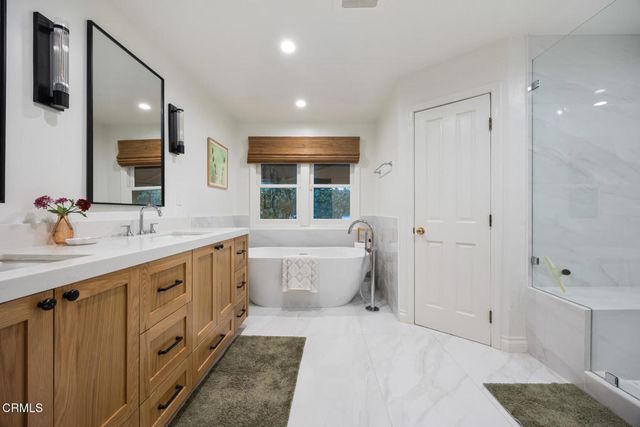 a spacious bathroom with a tub shower and mirror