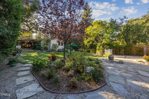 a view of a backyard with plants and lake view