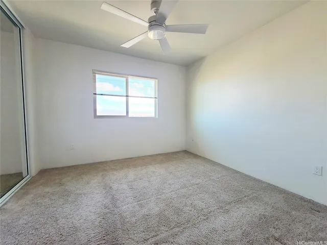 an empty room with a window and a fan