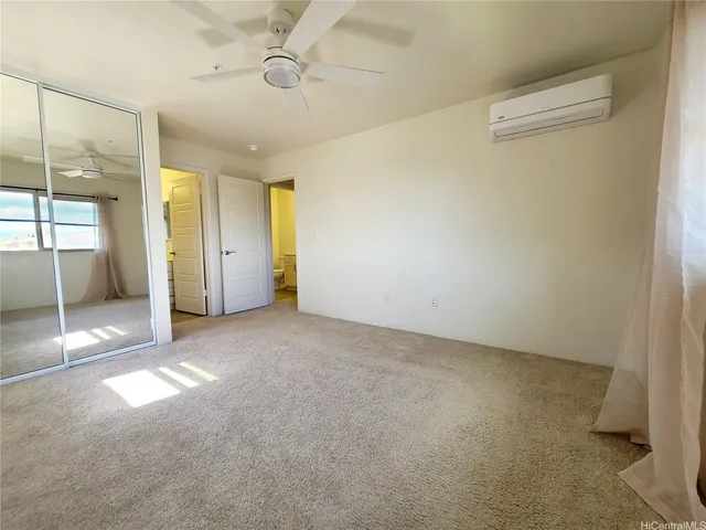 an empty room with windows and chandelier fan