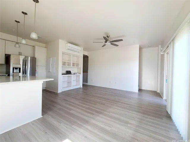 a view of a kitchen with wooden floor and a ceiling fan