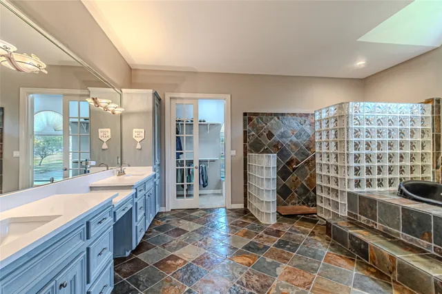 a large bathroom with a glass door shower and sink