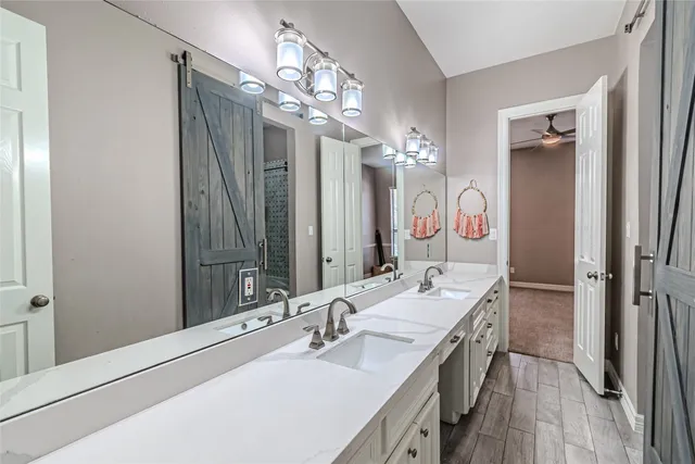 a bathroom with a double vanity sink mirror and shower