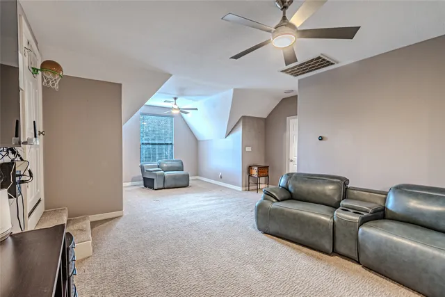 a living room with furniture and a gym machine