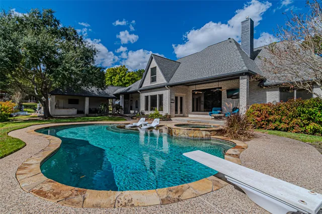 a view of a house with pool fire pit a patio and a yard