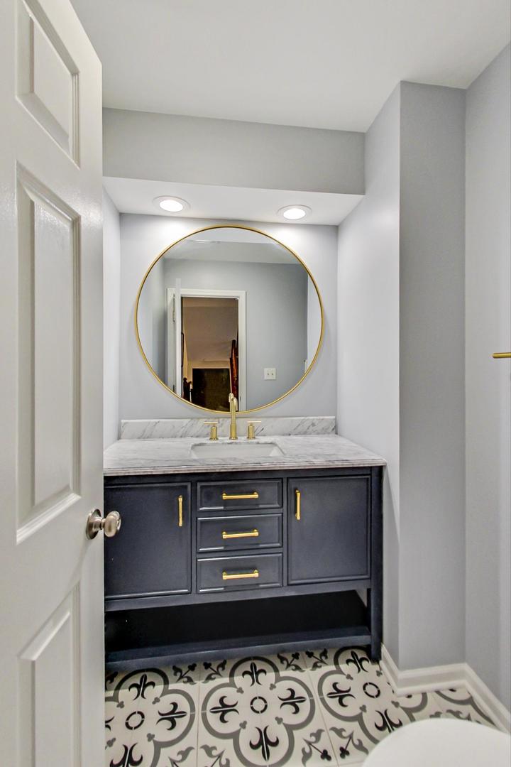 9024 Forestview Road Evanston, IL 60203 - Photo 18 of 41 a room with a mirror and a sink