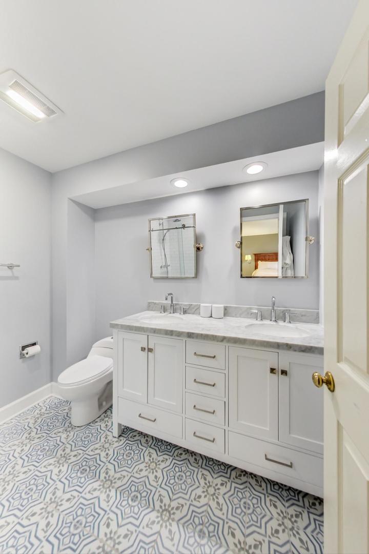 9024 Forestview Road Evanston, IL 60203 - Photo 22 of 41 a spacious bathroom with a granite countertop sink and a mirror