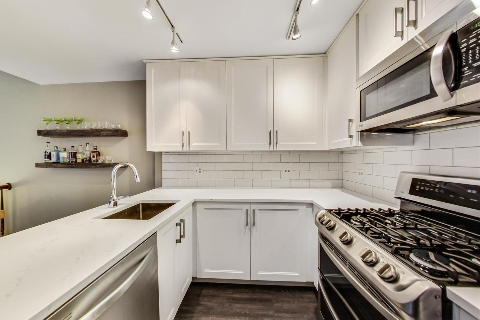9024 Forestview Road Evanston, IL 60203 - Photo 6 of 41 a kitchen with kitchen island a sink stove and cabinets