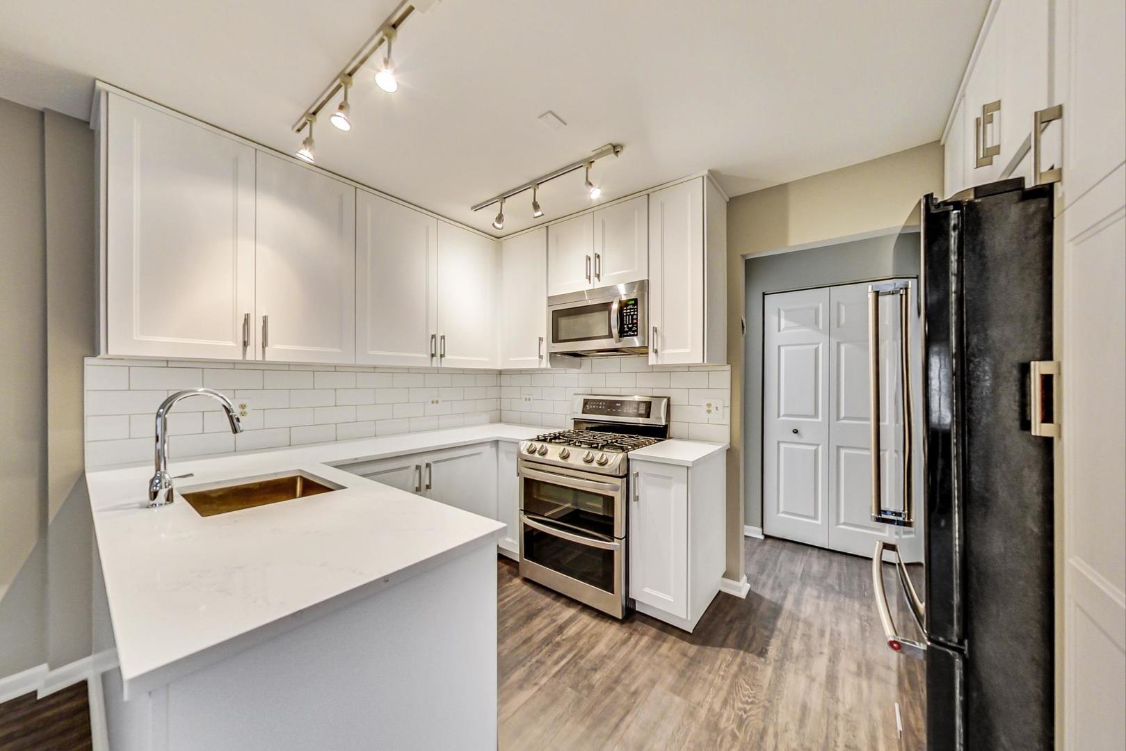 9024 Forestview Road Evanston, IL 60203 - Photo 7 of 41 a kitchen with a sink a counter top space stainless steel appliances and cabinets
