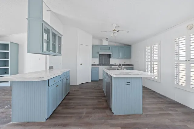 a kitchen with granite countertop a sink cabinets stainless steel appliances and a window