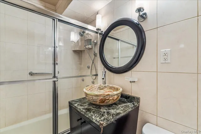 a bathroom with a granite countertop sink a mirror and a shower