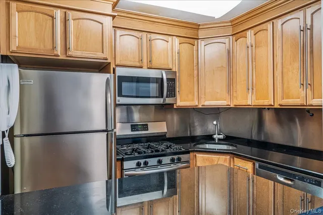 a kitchen with stainless steel appliances granite countertop a refrigerator and a stove top oven
