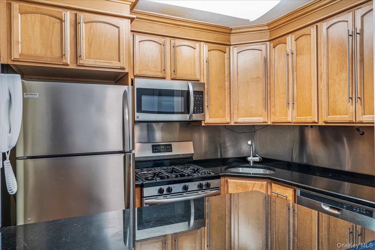 220-55 46th Avenue, Unit 5P Queens, NY 11361 - Photo 6 of 24 a kitchen with stainless steel appliances granite countertop a refrigerator and a stove top oven