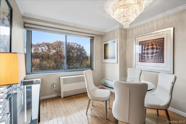 a view of a dining room with furniture a chandelier and wooden floor