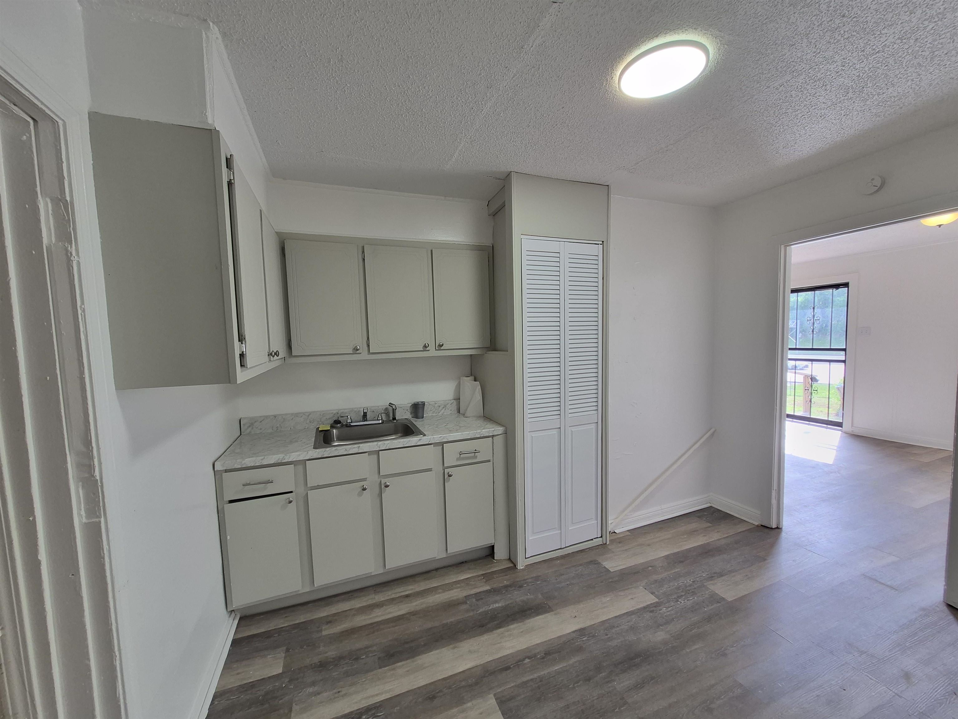 2100 Riverside Boulevard Memphis, TN 38109 - Photo 4 of 10 a view of a kitchen with sink cabinets and wooden floor