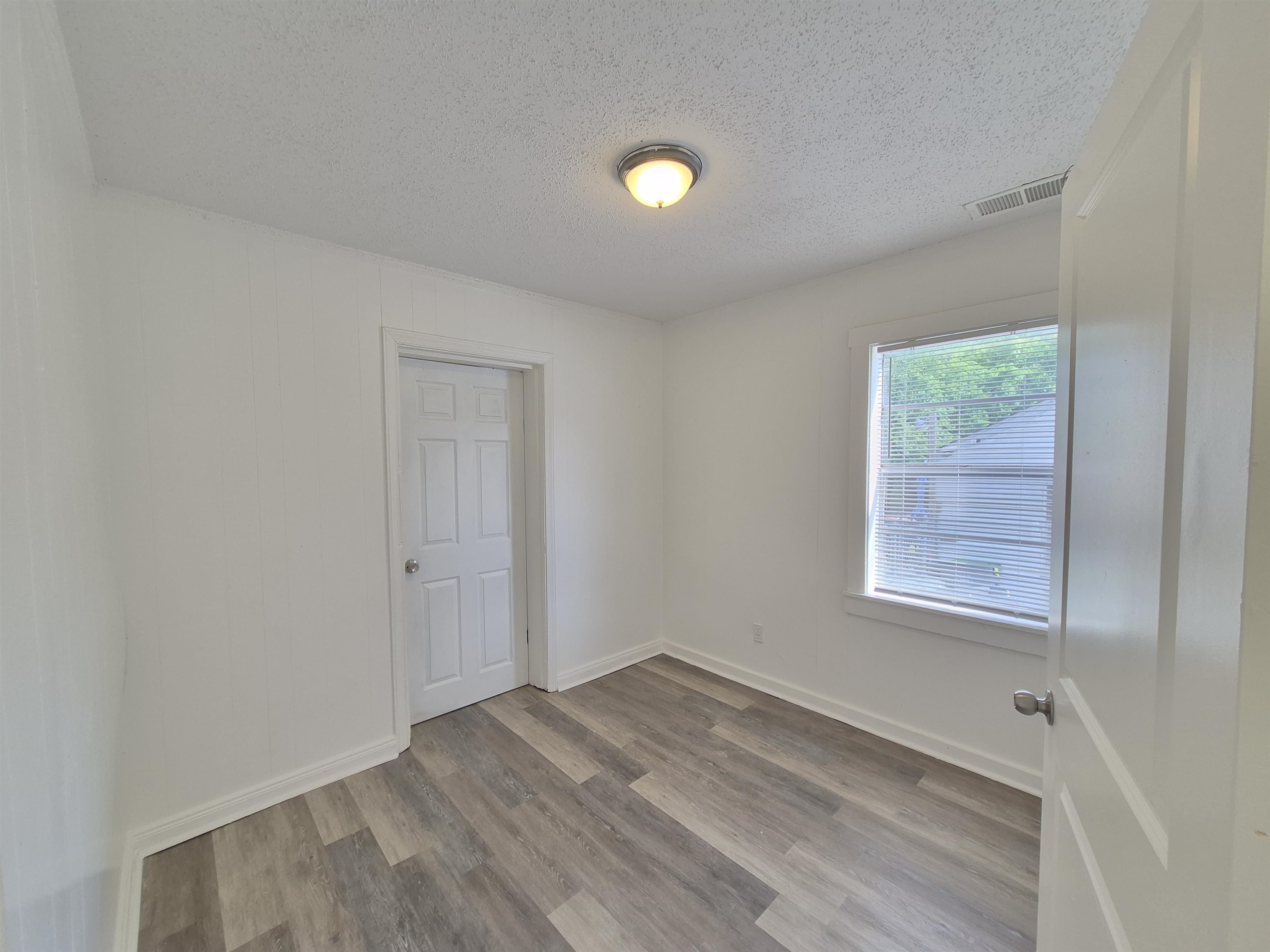 2100 Riverside Boulevard Memphis, TN 38109 - Photo 7 of 10 an empty room with a window and wooden floor