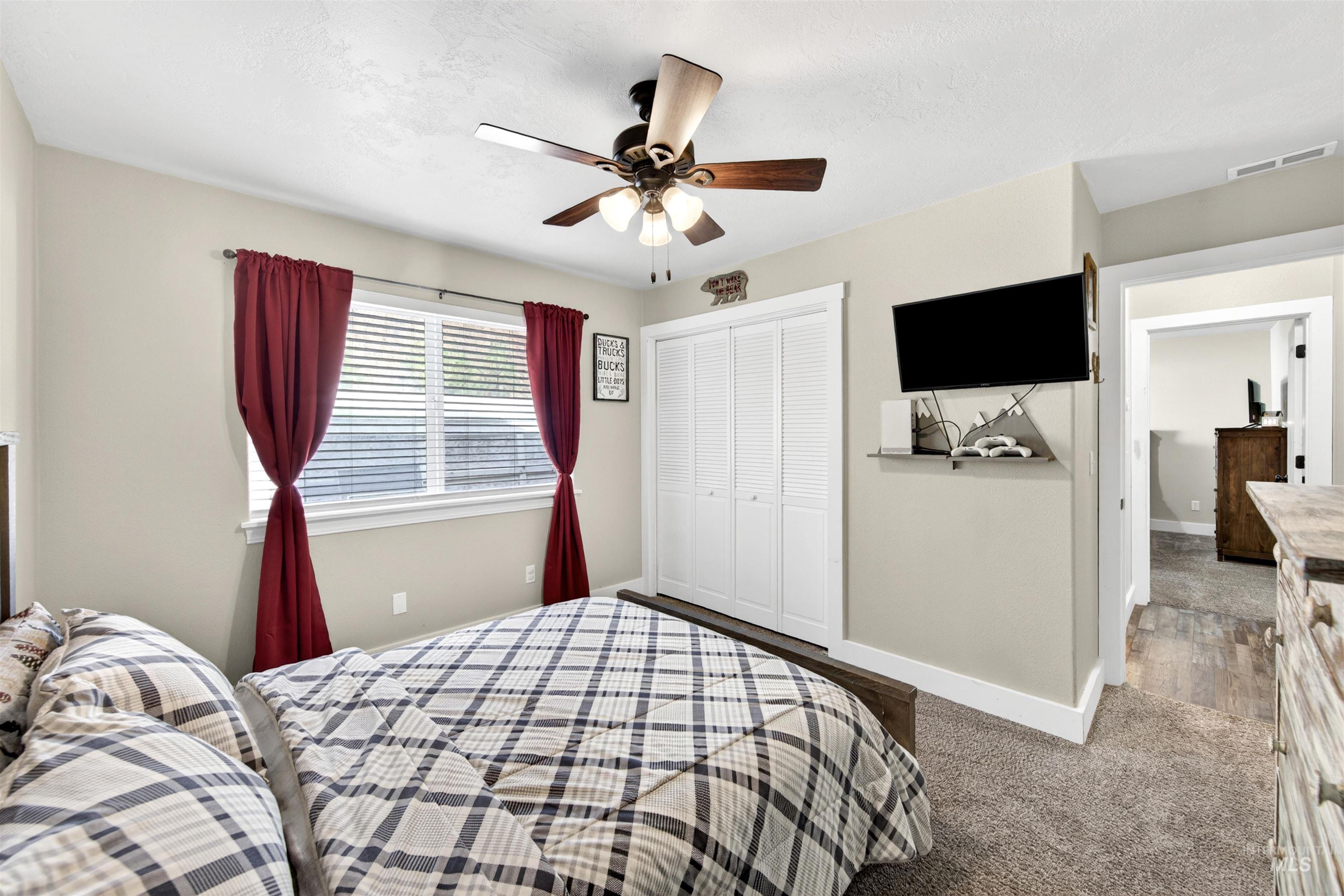 4 Round Up Circle Boise, ID 83716 - Photo 33 of 47 Carpeted room featuring a ceiling fan with integrated lighting, a window with blinds, and white bi-fold closet doors
