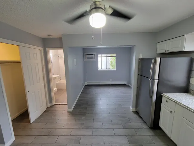 a kitchen with granite countertop a stove a sink and a refrigerator